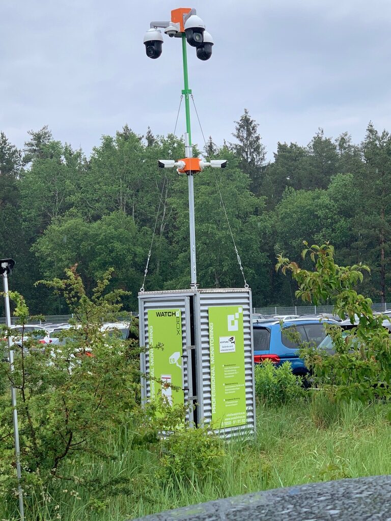 WatchBox steht auf einer Baustelle, daneben Pflanzen