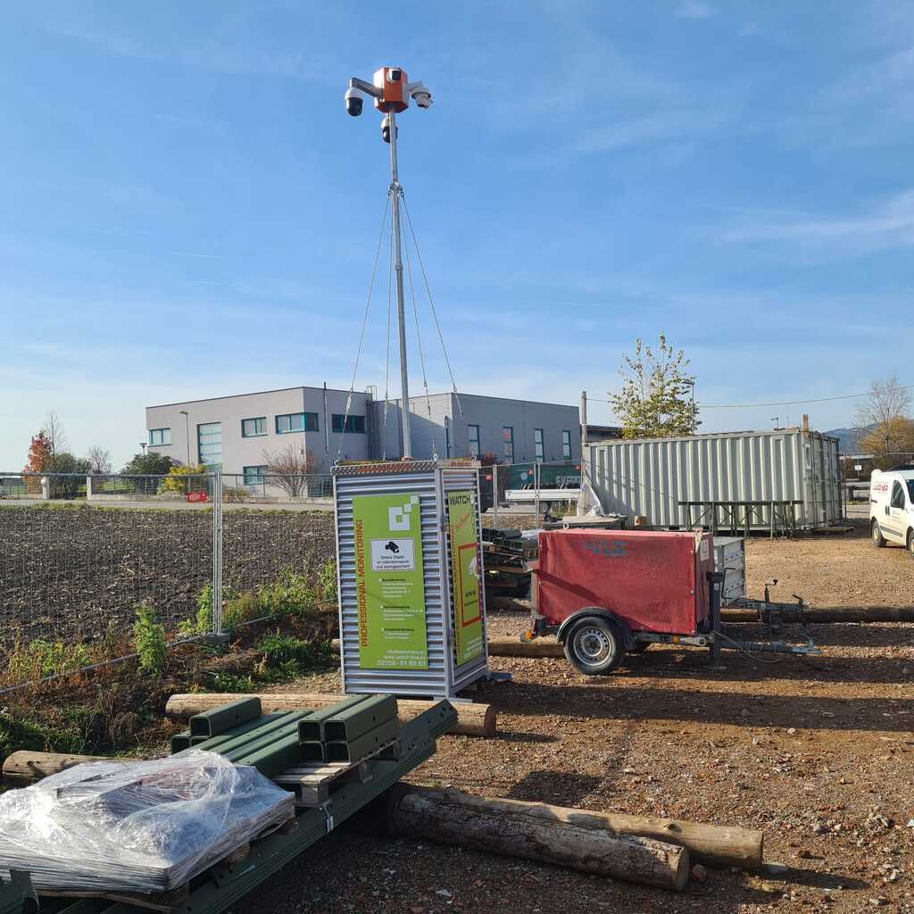 WatchBox steht auf einer Baustelle, Zaun im Hintergrund