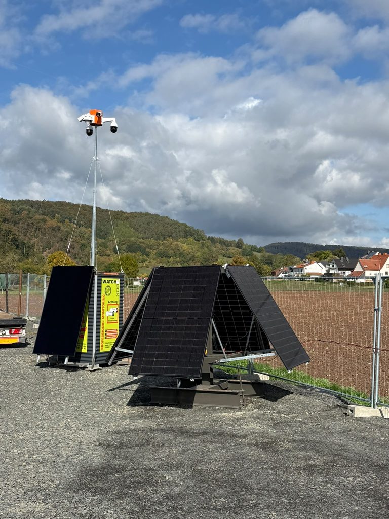 Mobile Ueberwachungsstation mit Solarpanels und Kameras auf einer Baustelle